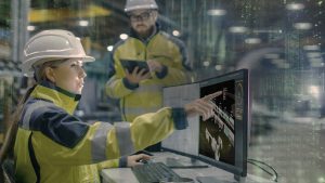 Zwei Techniker vor Monitor in Fertigungshalle