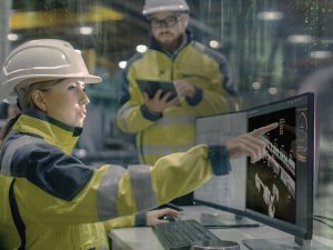 Zwei Techniker vor Monitor in Fertigungshalle